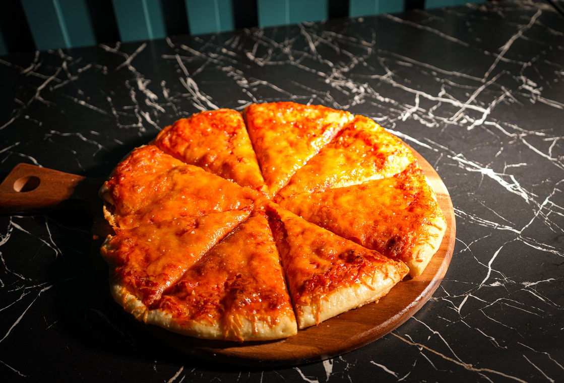 Cheese pizza slices on a wood board