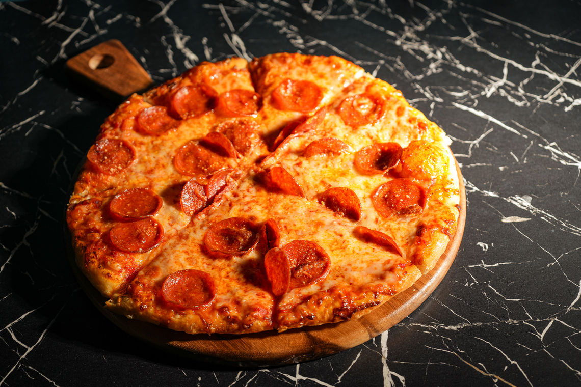 Pepperoni pizza on a wood board